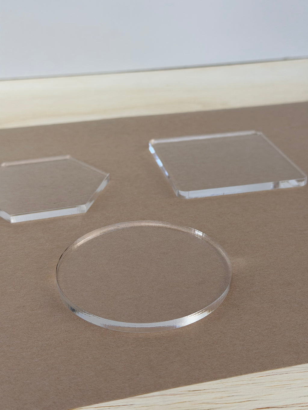 Close up of clear 1/4 inch acrylic coaster blanks with polished edges