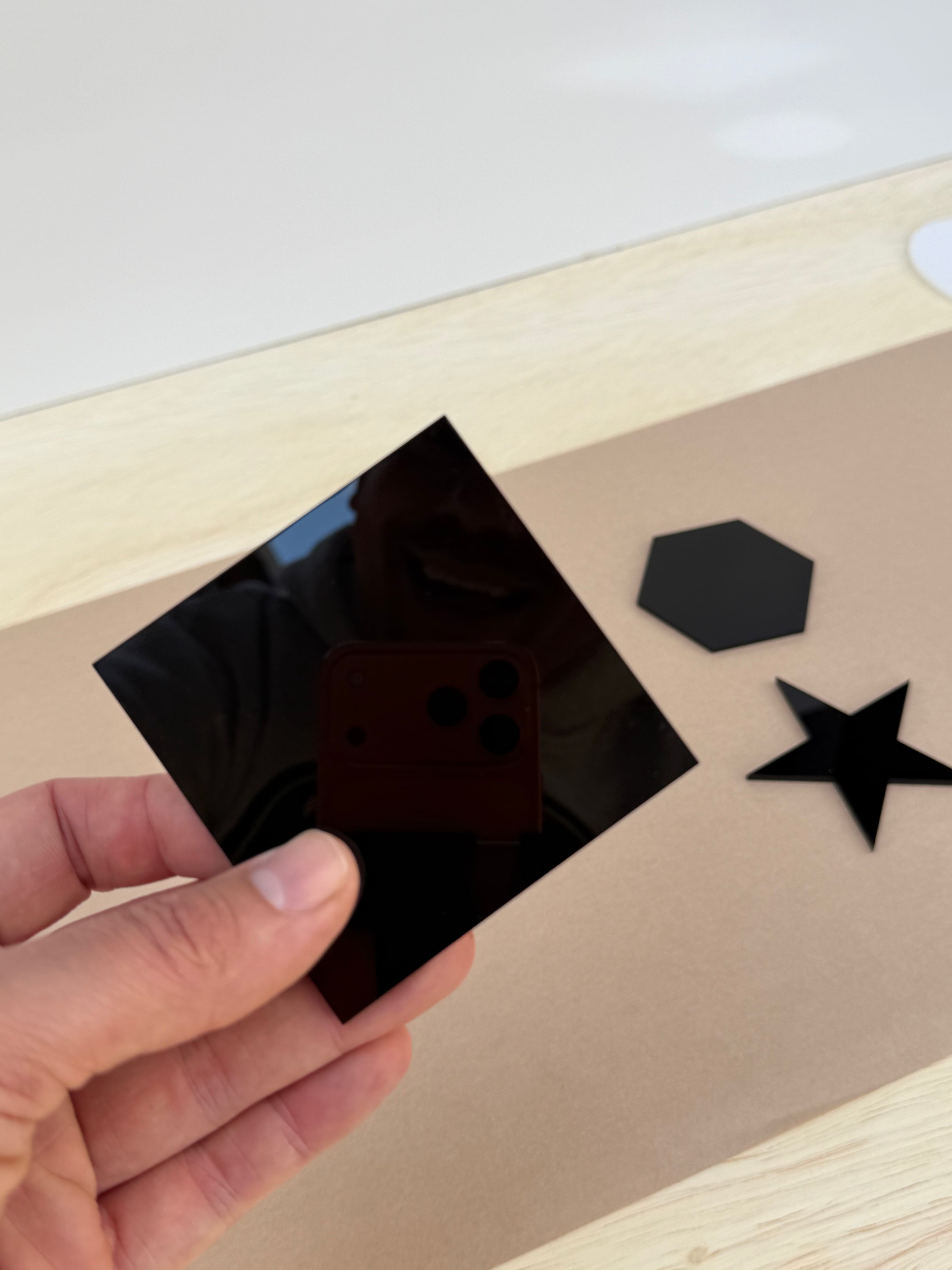 Black 1/8 inch acrylic square blank for UV printing held in hand to show size