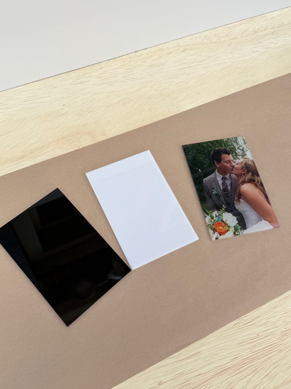 Black and white 4x6 inch acrylic blanks for UV printing next to a 4x6 photo print