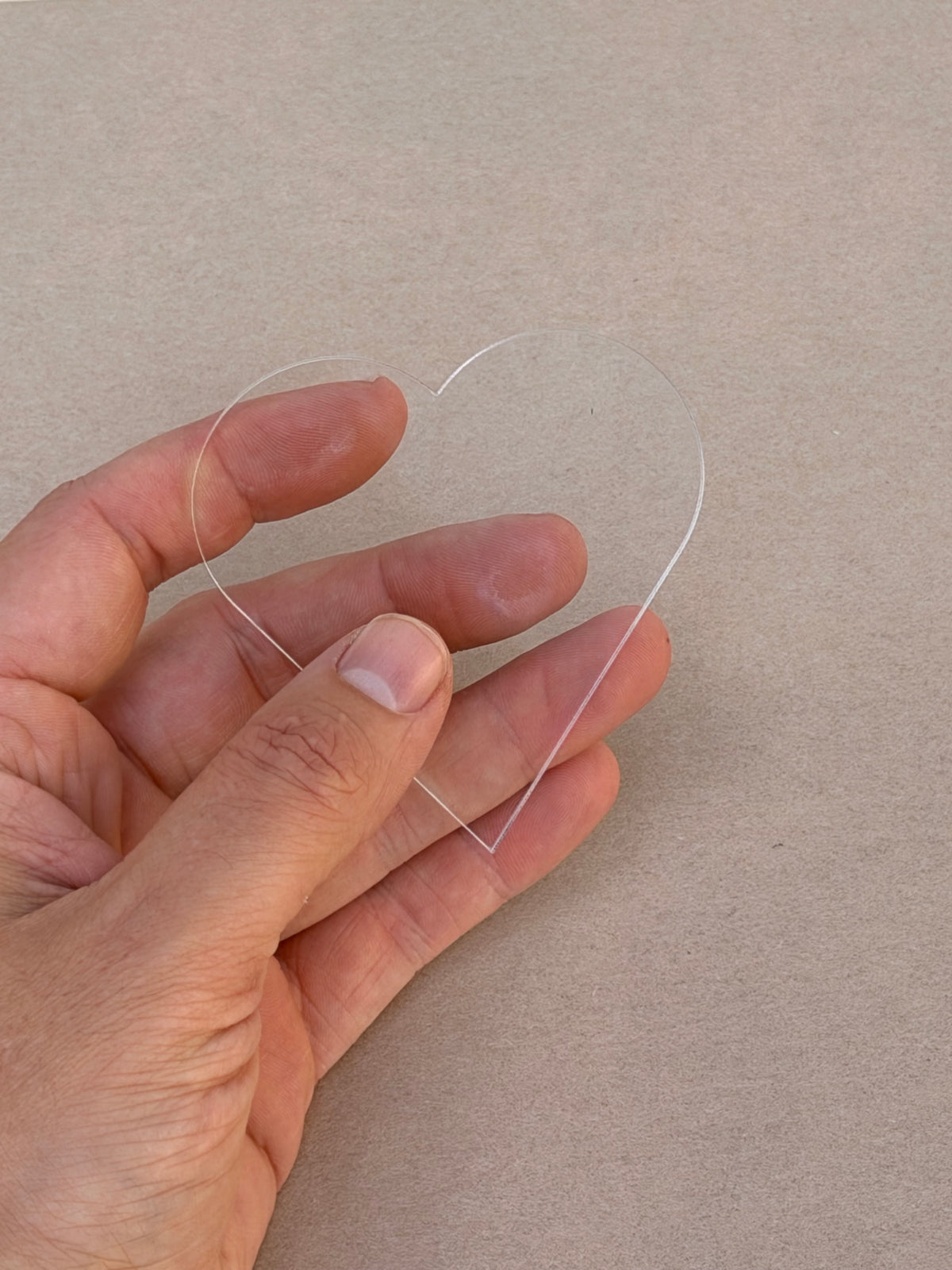 1/8 inch clear acrylic heart blank held in hand to show size
