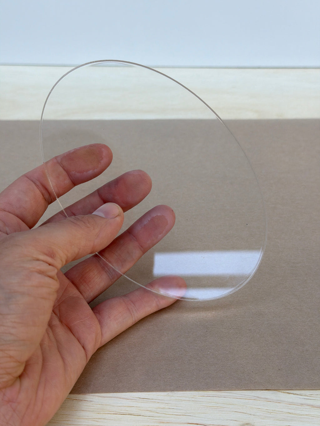 1/4 inch clear acrylic oval blank held in hand to show size