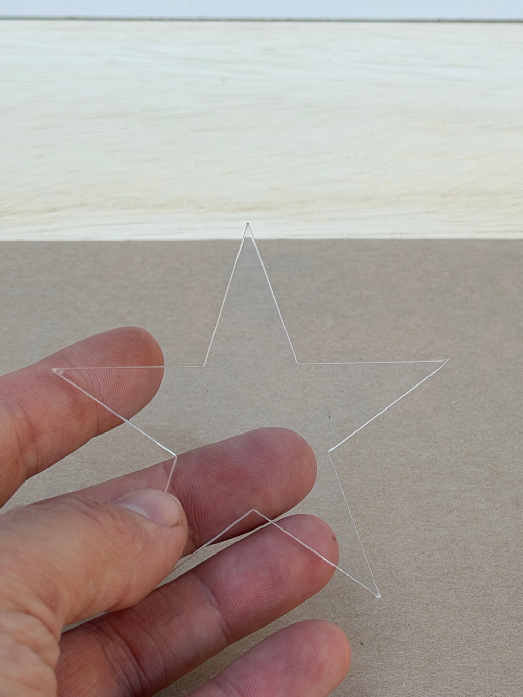 1/8 inch clear acrylic star blank held in hand to show size